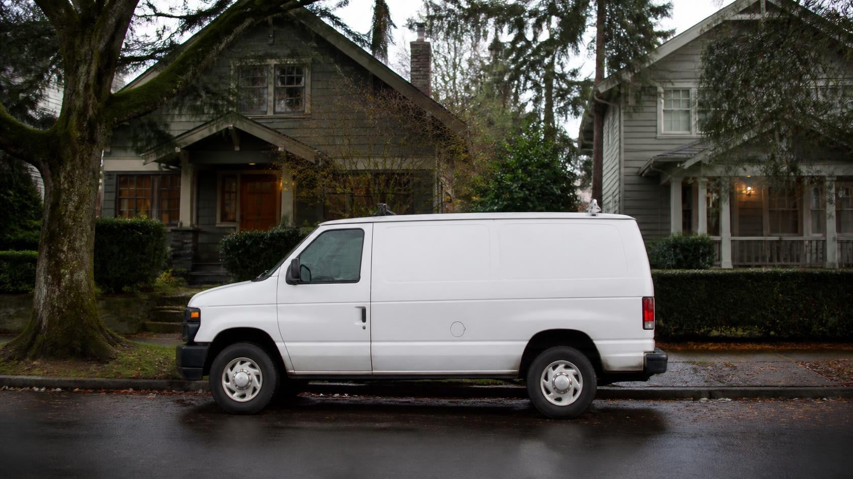 Contractor service van parked on a rain-wet residential street in a Washington state service area neighborhood